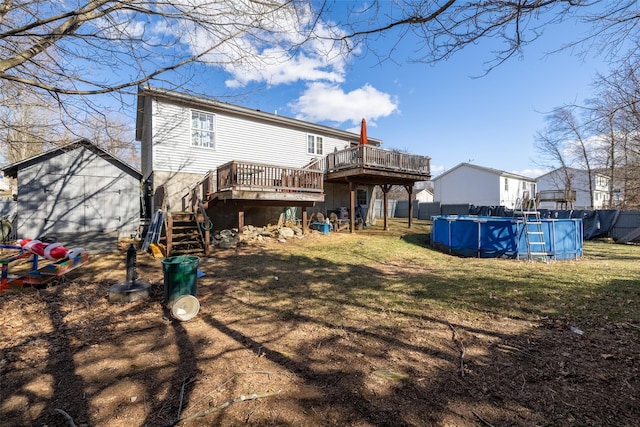 rear view of property featuring a fenced in pool, fence, a wooden deck, stairs, and a yard