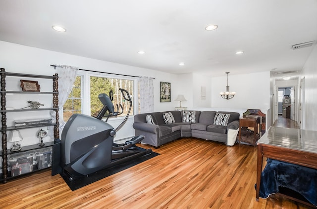 living room with hardwood / wood-style floors and a notable chandelier