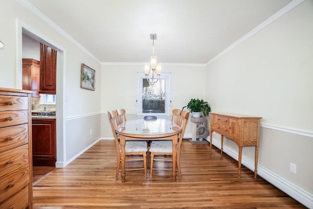 dining area with a chandelier, a baseboard heating unit, light hardwood / wood-style flooring, and ornamental molding