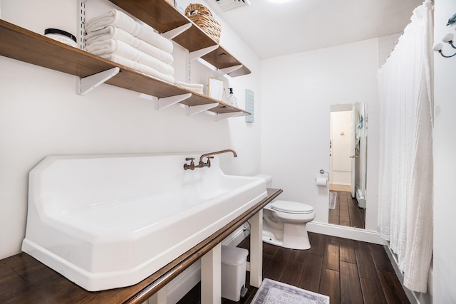 bathroom with toilet and wood-type flooring