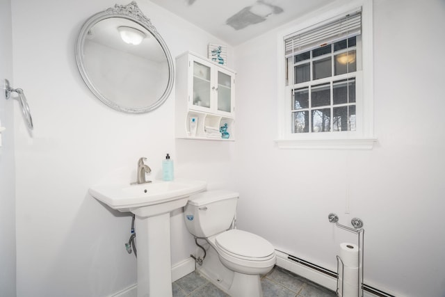 bathroom with tile patterned flooring, a baseboard radiator, toilet, and sink