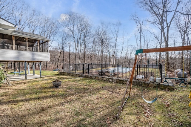 view of yard with a sunroom, a fire pit, and a playground