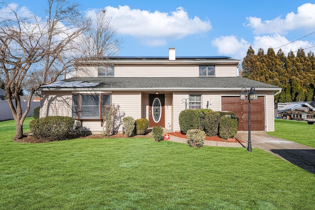 view of front of property with solar panels, a garage, and a front lawn