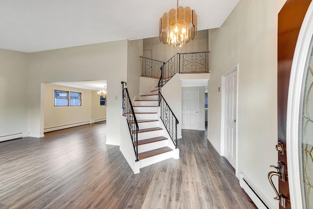 entrance foyer with a high ceiling, a chandelier, dark hardwood / wood-style floors, and a baseboard heating unit