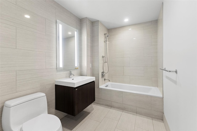 full bathroom featuring vanity, tiled shower / bath combo, tile walls, tile patterned flooring, and toilet