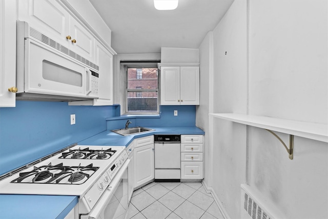 kitchen featuring white appliances, white cabinets, a sink, and light tile patterned floors