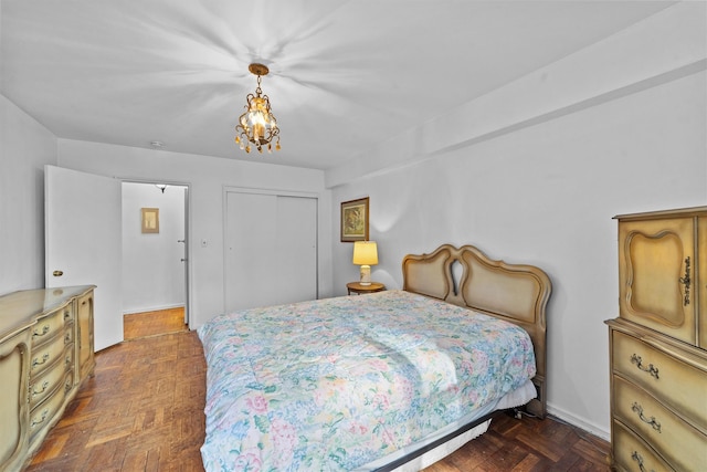 bedroom featuring a chandelier, a closet, and baseboards