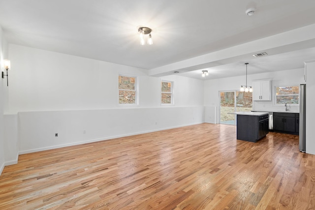 unfurnished living room with light hardwood / wood-style floors and sink