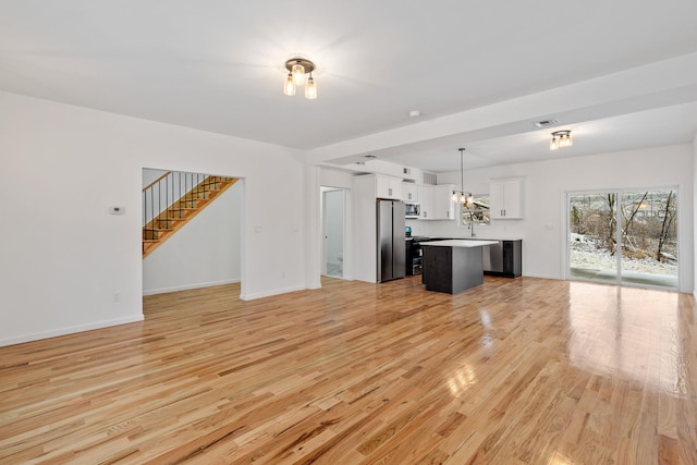 unfurnished living room with sink and light hardwood / wood-style flooring