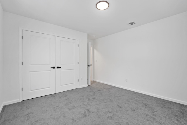 unfurnished bedroom featuring carpet floors and a closet