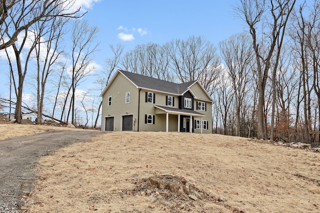 view of property with covered porch and a garage