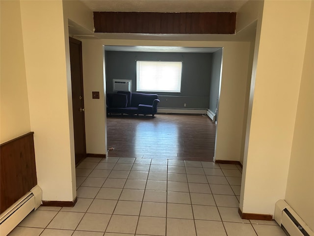 hallway with a baseboard radiator, a wall mounted air conditioner, and light tile patterned floors