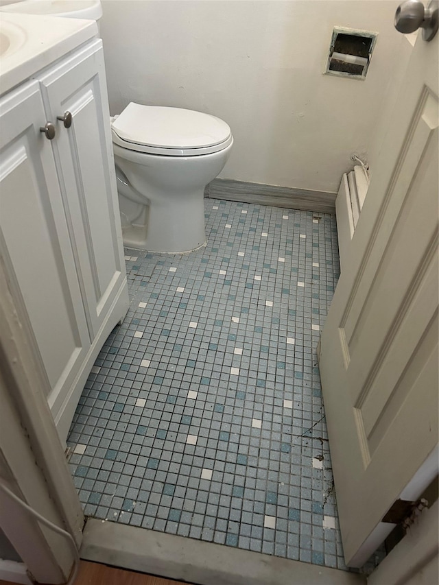 bathroom with toilet, tile patterned flooring, and vanity