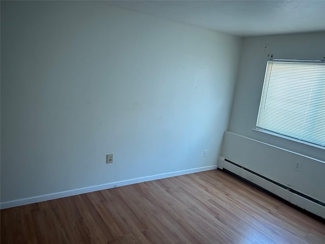 spare room featuring light wood-type flooring and baseboard heating