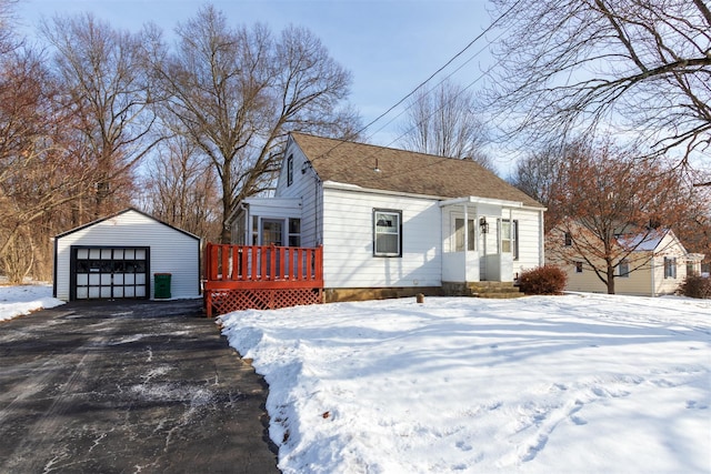 view of snow covered exterior featuring a garage and an outdoor structure