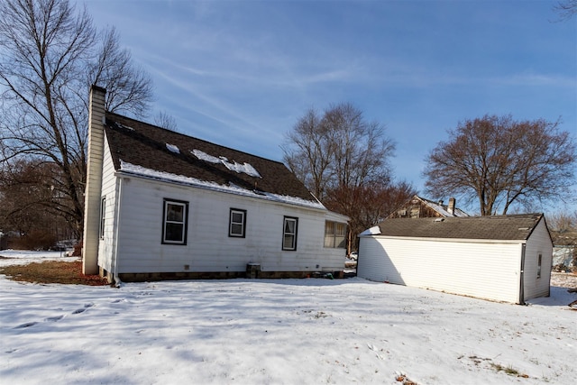 view of snow covered rear of property