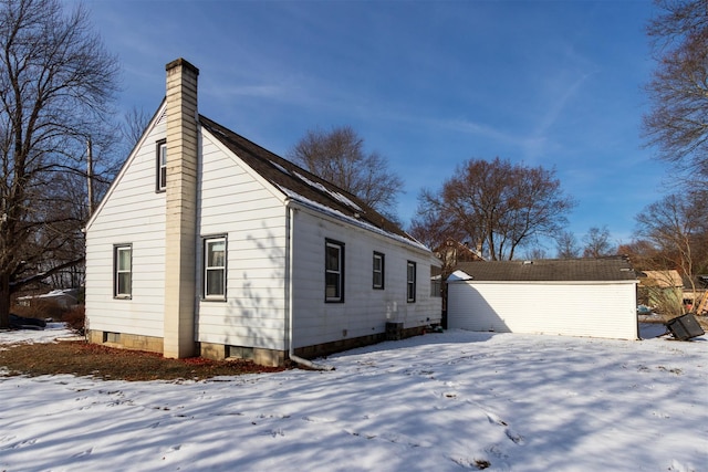 view of snow covered exterior featuring an outbuilding