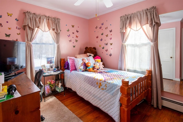 bedroom featuring wood-type flooring, ornamental molding, ceiling fan, and a baseboard heating unit