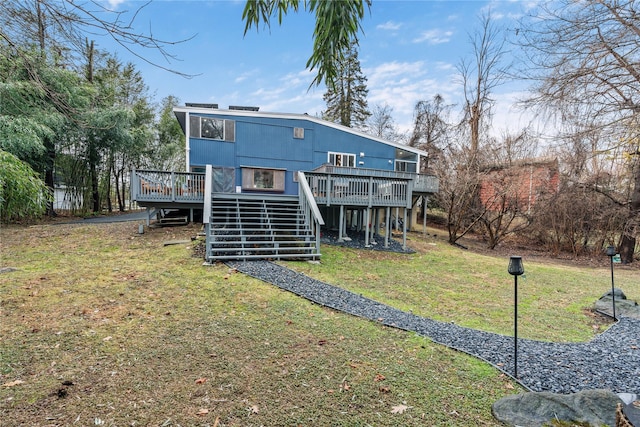 back of property featuring a lawn and a wooden deck