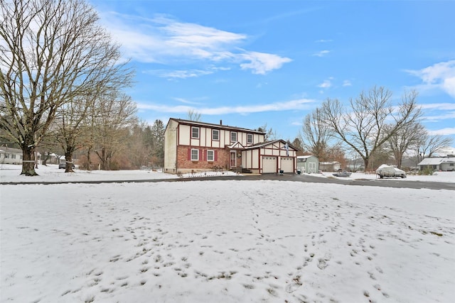 snow covered property with a garage