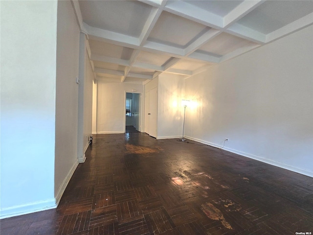 spare room with beam ceiling, dark parquet flooring, and coffered ceiling