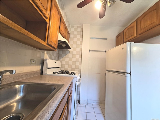 kitchen with white appliances, sink, ceiling fan, light tile patterned floors, and tasteful backsplash