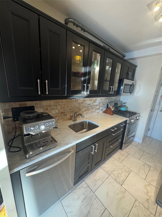 kitchen featuring decorative backsplash, stainless steel appliances, and sink