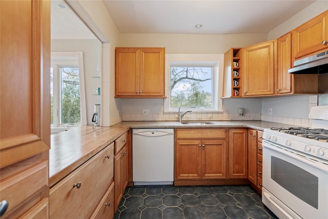 kitchen with kitchen peninsula, white appliances, range hood, and sink