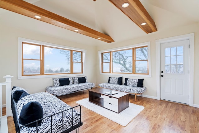 living room with lofted ceiling with beams, light hardwood / wood-style flooring, and a wealth of natural light