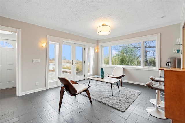 sitting room with crown molding and french doors