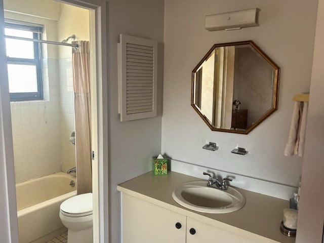 full bathroom featuring tiled shower / bath combo, toilet, and vanity