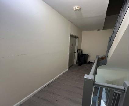 corridor with dark hardwood / wood-style flooring