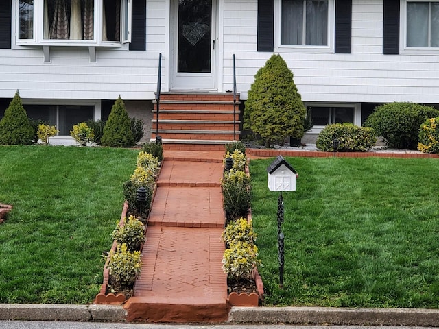 entrance to property featuring a lawn