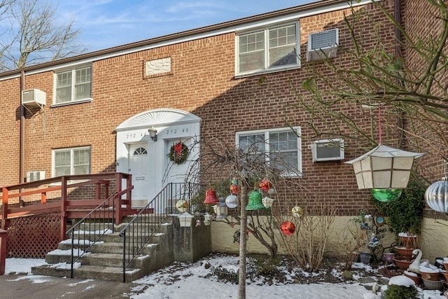 view of front of home with a wall mounted air conditioner and a wooden deck