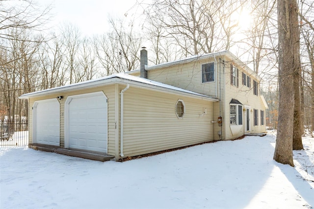 view of snowy exterior with a garage