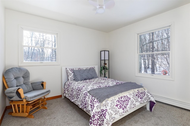 bedroom with multiple windows, carpet floors, baseboard heating, and ceiling fan