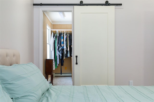 bedroom with carpet flooring, a barn door, a closet, and a baseboard radiator