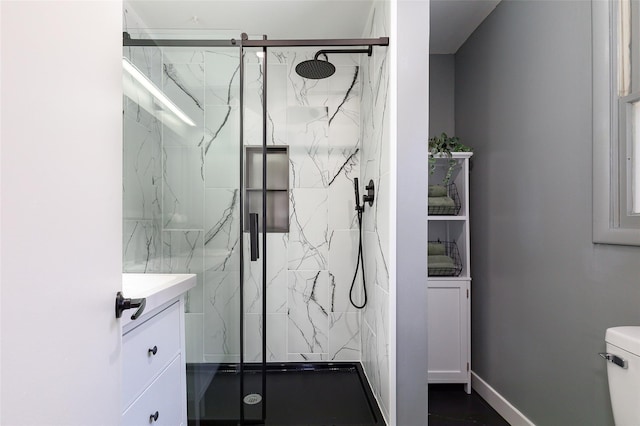 bathroom with vanity, toilet, and a shower with door