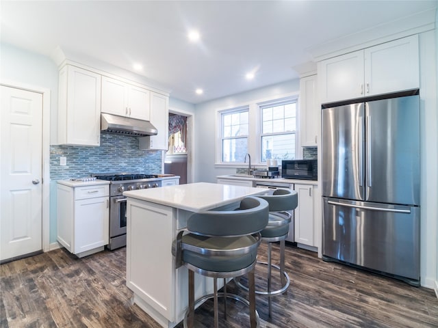 kitchen featuring a kitchen breakfast bar, white cabinetry, a kitchen island, and stainless steel appliances