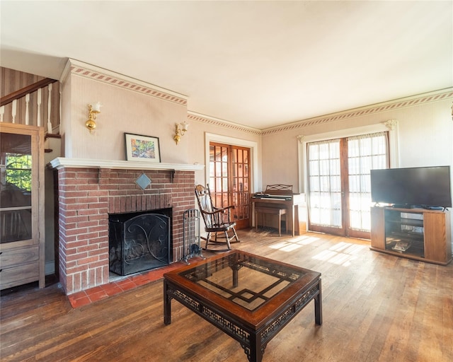 living room featuring a brick fireplace, hardwood / wood-style flooring, and french doors