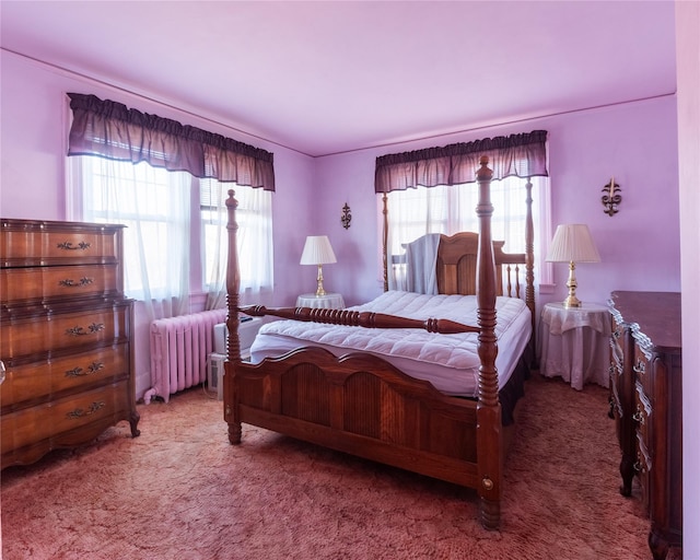 carpeted bedroom featuring multiple windows and radiator heating unit