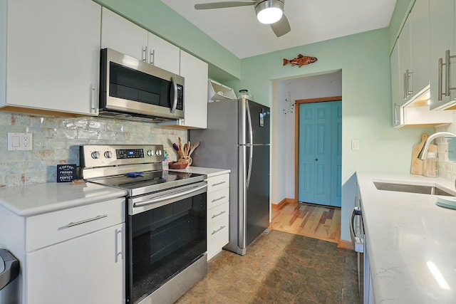 kitchen featuring appliances with stainless steel finishes, backsplash, ceiling fan, sink, and white cabinets