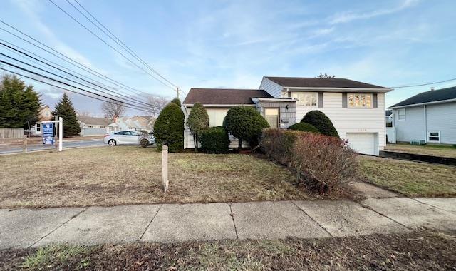 view of front of property featuring a front yard and a garage