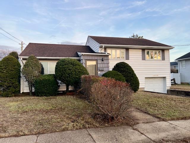 view of front of property featuring a garage and a front lawn