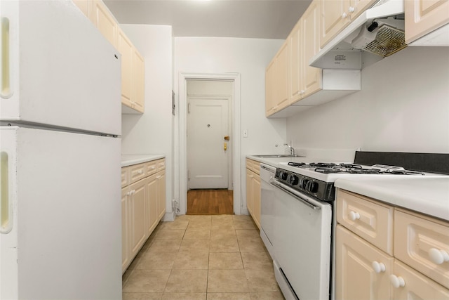 kitchen featuring light tile patterned floors, white appliances, and sink