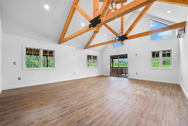 unfurnished living room with beamed ceiling, hardwood / wood-style flooring, high vaulted ceiling, and an AC wall unit