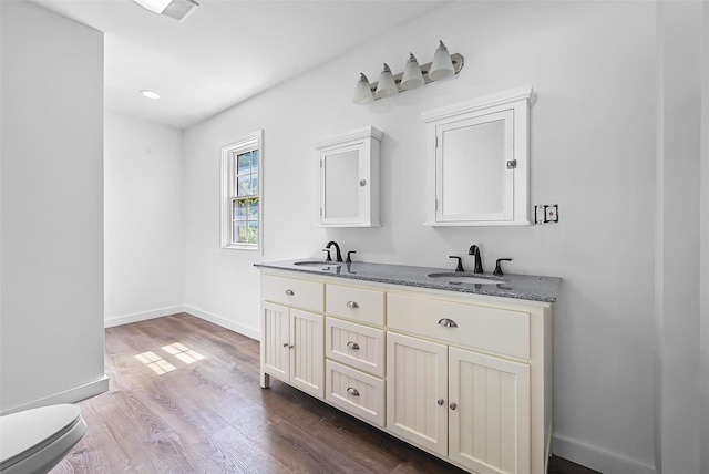 bathroom with hardwood / wood-style floors, vanity, and toilet