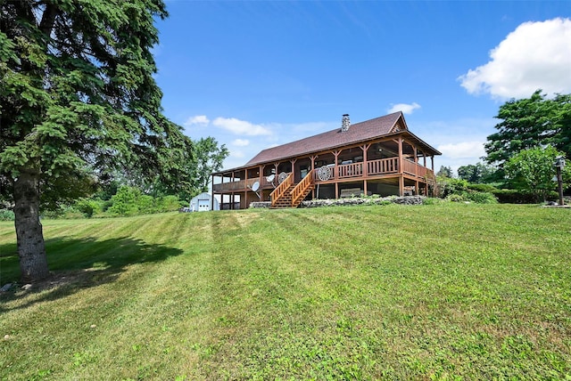 back of house with a deck and a yard