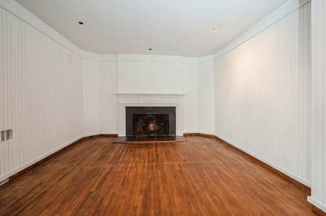 unfurnished living room with hardwood / wood-style floors and a tile fireplace