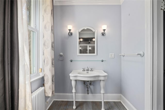 bathroom featuring hardwood / wood-style flooring, ornamental molding, and radiator heating unit